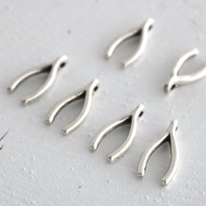 Peut inclure: Six breloques en forme de fourchette à souhaits en argent, chacune avec une boucle en haut pour les attacher à des bijoux ou d'autres objets artisanaux.