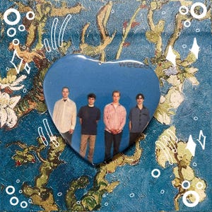 May include: A blue heart-shaped pin with a picture of four people on it. The pin says "weezer" at the top.