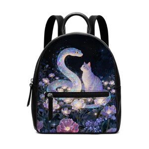 Könnte beinhalten: Schwarzer Rucksack mit einer Fantasy-Illustration einer leuchtenden Schlange und einer Katze inmitten von Blumen. Das Design umfasst eine Reißverschlusstasche und schwarze Träger. Das Kunstwerk hat ein himmlisches Thema mit dunklem Hintergrund und leuchtenden Farben.