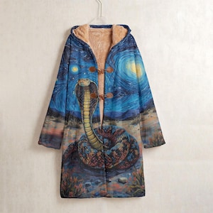 May include: A long hooded coat with a striking print of a cobra set against a starry night sky, in the style of Van Gogh. The coat has a brown toggle closure and a soft, tan-coloured interior lining.
