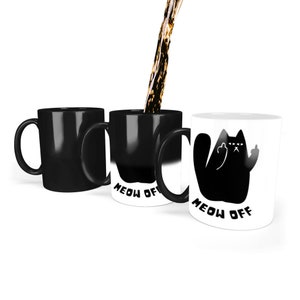 Puede incluir: Tres tazas negras sensibles al calor con el texto "MEOW OFF" y una silueta de gato negro haciendo el dedo medio. La taza de la derecha es blanca y muestra el diseño cuando está caliente.