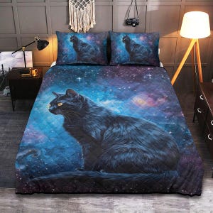 May include: A quilted bedspread and two pillowcases feature a black cat against a cosmic background of blue, purple, and white. The cat has yellow eyes and is the focal point of the bedding set. The bedding set is designed to fit a queen-sized bed.