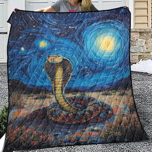 Puede incluir: Una manta acolchada con un diseño de cobra sobre un cielo estrellado. La serpiente se muestra con la capucha levantada, y el fondo tiene un aspecto arremolinado y texturizado con una gran luna y estrellas. La combinación de colores incluye azules, amarillos y tonos tierra.