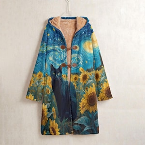 Peut inclure: Un long manteau avec un chat noir dans un champ de tournesols sous un ciel étoilé. Le manteau a une capuche, des fermetures à bascule et une doublure intérieure marron clair. Le manteau est suspendu à un cintre blanc.