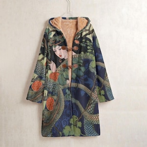 Puede incluir: Un abrigo largo con capucha con un diseño artístico único. El abrigo presenta un fondo azul oscuro con una impresión de una mujer, serpientes y follaje. Tiene un forro de piel sintética marrón y cierres de palanca de madera. El abrigo está colgado en una percha.