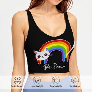 May include: Black crop top featuring a white cat with a rainbow tail and the text "Be Proud". The top has a scoop neck and is sleeveless. The cat graphic is set against a rainbow. The top is designed for comfort and light weight.