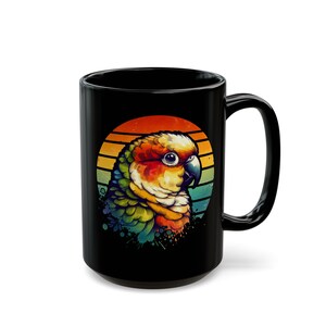 Könnte beinhalten: Schwarze Keramiktasse mit einer bunten Illustration eines Papageis vor einem Retro-Sonnenuntergang.
