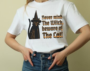 May include: White t-shirt with a black cat wearing a witch hat and the text "Never mind The Witch, beware of The Cat!"