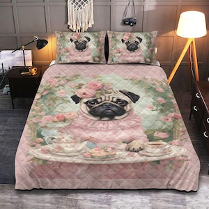 Op de afbeelding: Een roze gewatteerde sprei en twee kussenslopen tonen een grillige mopshond met een roze jurk en een bloemenkrans. De mopshond wordt afgebeeld met een theeservies op een dienblad. Het beddengoed heeft een bloemrijke en groene achtergrond.