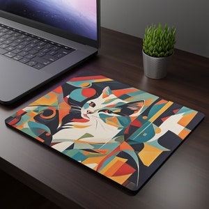 May include: A colorful abstract mousepad with a white cat with black ears and a geometric design. The cat is looking to the right.