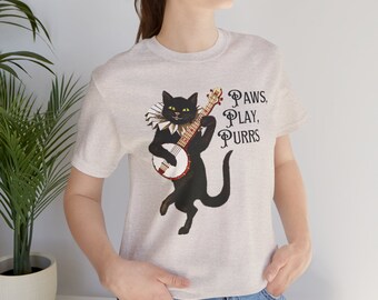 May include: A heather grey t-shirt featuring a black cat playing a banjo with a white collar and the text "PAWS, PLAY, PURRS".
