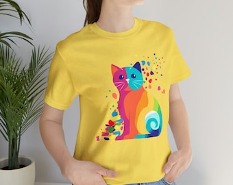 Könnte beinhalten: Ein gelbes T-Shirt mit einem farbenfrohen abstrakten Katzendesign. Die Katze sitzt und hat einen regenbogenfarbenen Körper mit blauen und grünen Akzenten. Das Design ist von bunten Punkten und Wirbeln umgeben.