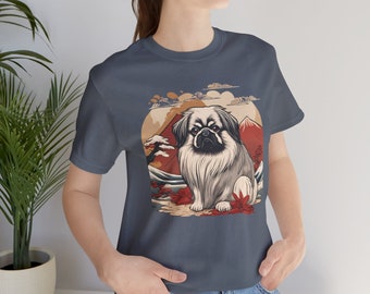 May include: A navy blue t-shirt with a graphic of a Pekingese dog in front of a Japanese mountain scene. The dog is white and gray with black eyes and a black nose. The mountain scene is red, orange, and yellow.