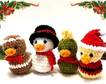 May include: Four crocheted Christmas-themed duck figurines. The ducks are dressed as a gingerbread man, snowman, Christmas tree, and Santa Claus. Each duck has an orange beak and is wearing a hat or scarf. The background is white with Christmas decorations.