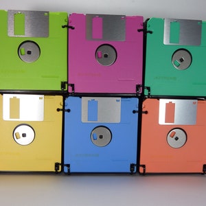 May include: Six colourful floppy disks stacked in a 2x3 grid. The disks are green, pink, teal, yellow, blue, and orange.