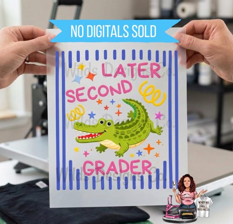 Pu&ograve; includere: Un foglio di vinile termotrasferibile con la scritta "Later Second Grader" e un alligatore dei cartoni animati. Il disegno comprende stelle, coriandoli e strisce verticali blu. Lo striscione in alto recita "NO DIGITALS SOLD".