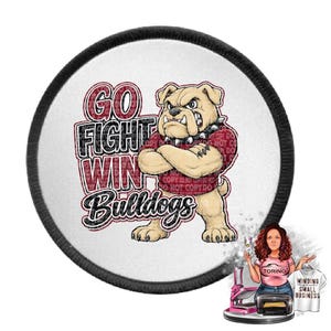 May include: A circular patch with a black stitched border featuring a cartoon bulldog with crossed arms wearing a red shirt. The text reads GO FIGHT WIN Bulldogs in black and red lettering. A small illustration of a person and a shirt is visible.