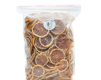 May include: A transparent bag containing numerous dried orange slices. The slices are circular, featuring a brown centre and an orange peel. A white sticker with "COCKTAIL CANDY" and a cocktail illustration is on the bag. The bag is sealed with a clear plastic closure.