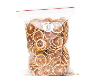 May include: A transparent bag containing dried lemon slices. The bag has a red zip closure and a label with the text "COCKTAIL CANDY" and a cocktail glass graphic. The lemon slices are brown and yellow.