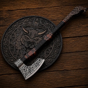May include: A dark brown wooden axe with a carved wolf head handle and a metal blade featuring intricate knotwork patterns and the text SACRIFICD BOLR VAINHALITY PRIAILA, resting on a circular wooden shield with a carved wolf face design.