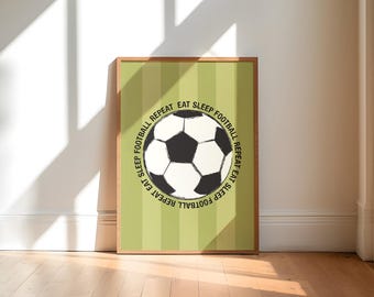 May include: A framed print featuring a black and white soccer ball design with the words "EAT SLEEP FOOTBALL REPEAT" in a circular pattern. The background is light green with vertical stripes. The frame is brown.