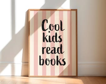 May include: A framed print with a light wood frame. The print features a striped background of alternating pink and cream vertical stripes. The words "Cool kids read books" are written in black script.