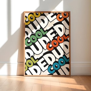 May include: A framed art print with the words "DUDE" and "COOL" in a repeating pattern. The words are in a bold, retro font with black outlines and colorful accents of yellow, green, orange, and blue. The frame is a light brown wood.