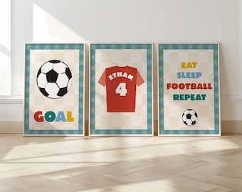 May include: Three framed prints with a soccer theme. One print shows a soccer ball and the word "GOAL" in colorful letters. Another features a red jersey with the name "Ethan" and the number "4". The third print says "EAT SLEEP FOOTBALL REPEAT".