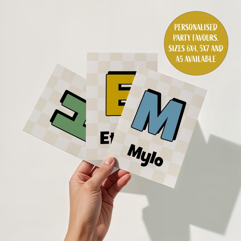 Puede incluir: Tres tarjetas personalizadas para recuerdos de fiesta con las letras E, M y Z en verde, amarillo y azul, con el nombre Mylo. Las tarjetas tienen un fondo a cuadros y el texto "FAVORES DE FIESTA PERSONALIZADOS. TAMA&Ntilde;OS 6X4, 5X7 Y A5 DISPONIBLES" en un c&iacute;rculo dorado.