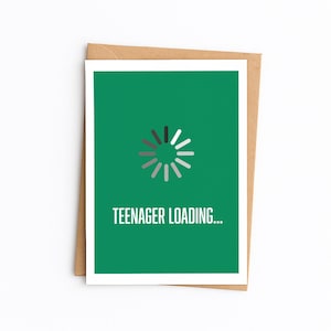 Peut inclure: Carte de vœux avec un fond vert et le texte "TEENAGER LOADING...". La carte présente un symbole de chargement au centre. La carte est à l'intérieur d'une enveloppe marron.