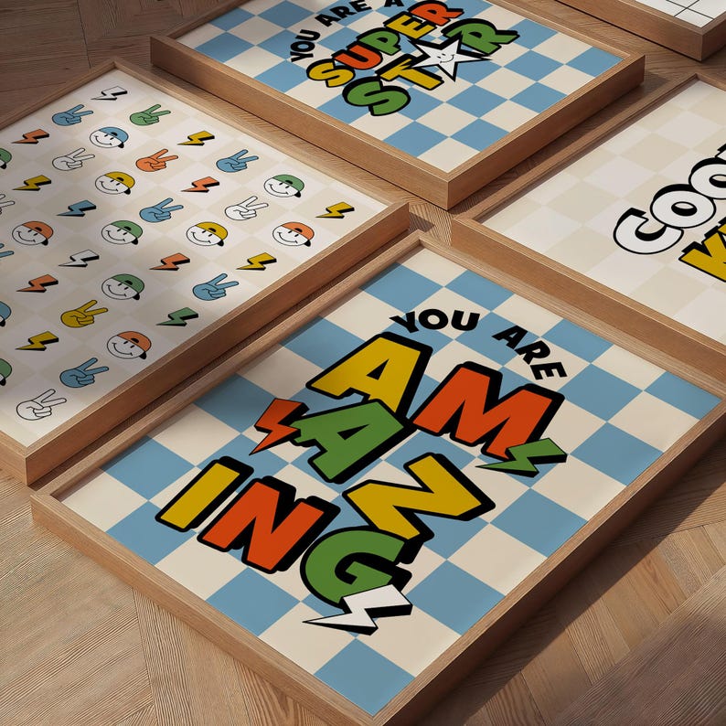 May include: Wooden framed art prints with positive messages. One print says "You are Amazing" in orange, green, and yellow letters with lightning bolt accents on a blue and white checkered background. Other prints have similar designs and messages.