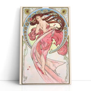 May include: Art Nouveau print depicting a woman in a pink dress with long auburn hair. The artwork has a circular design with floral and geometric patterns in gold, blue, and green. Petals fall around the woman, adding to the romantic feel.