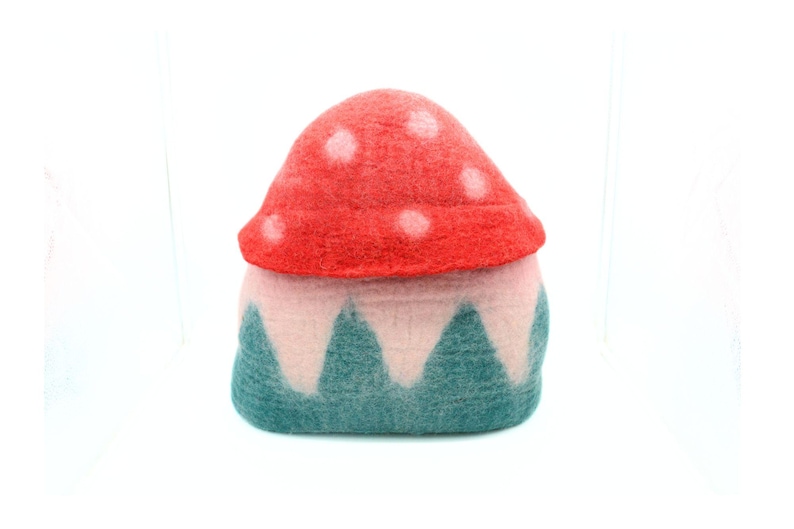 May include: A felt mushroom house with a red and white top and a green and pink base.