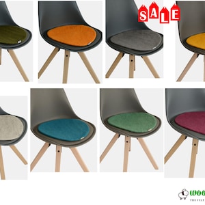 May include: A collection of modern chairs with gray seats and wooden legs, each featuring a colorful felt seat cushion. Colors include green, orange, gray, yellow, beige, teal, dark green, and burgundy. The word "SALE" is visible in the top right corner.