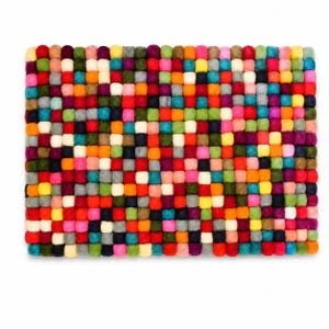 Può includere: Un tappetino rettangolare composto da una fitta griglia di piccole sfere di feltro in una vibrante gamma di colori, tra cui rosso, arancione, giallo, verde, blu, viola, rosa, bianco e grigio, disposte in un motivo multicolore ripetuto.