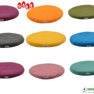 May include: Nine colorful, round felt seat cushions in various shades, including purple, orange, green, gray, yellow, blue, pink, and teal. Each cushion has a small white tag and the word "SALE" is visible at the top.