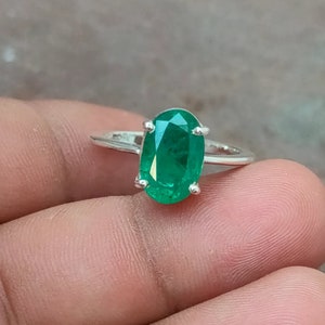 Könnte beinhalten: Ein silberner Ring mit einem großen, ovalen Smaragd.