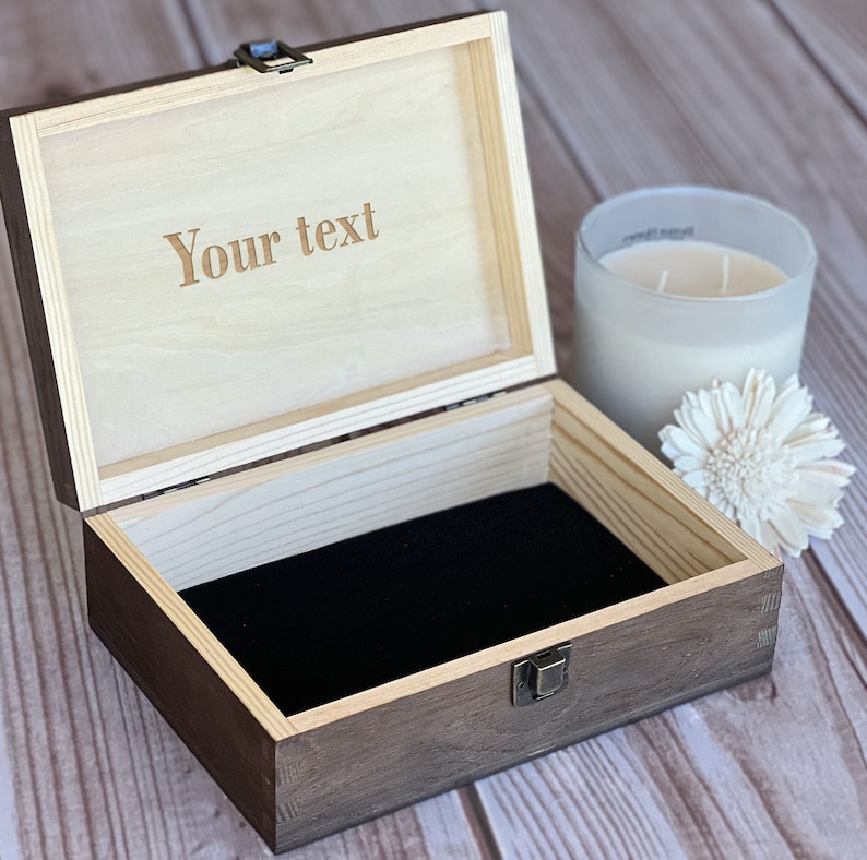 Pu&ograve; includere: Una scatola di legno con un coperchio incernierato e un rivestimento in velluto nero. Il coperchio &egrave; inciso con il testo "Your text".