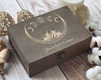 May include: A dark brown wooden box with a hinged lid and a brass latch. The box has a design of a crescent moon with stars and the text "Your text or name" engraved on the top.