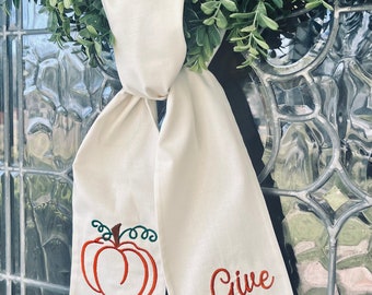 Ivory wreath sash with embroidered open  pumpkin and “Give Thanks”