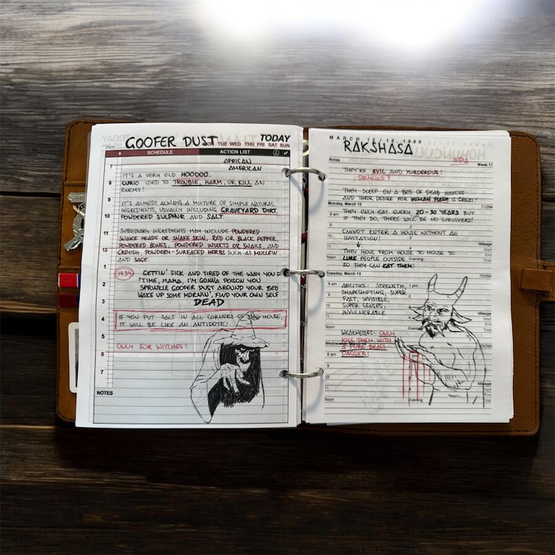 May include: A leather-bound planner open to two pages with handwritten notes and illustrations. One page is titled "Goober Dust" with a schedule and action list. The other page is titled "Rakshasa" with notes. The planner is on a wooden surface.