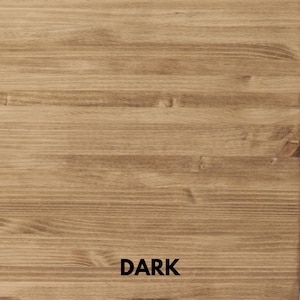 May include: Close-up of a wooden surface with a dark brown stain. The wood grain is visible, with horizontal lines and knots. The word "DARK" is printed in black at the bottom of the image.