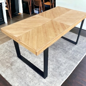 Può includere: Tavolo da pranzo rettangolare in legno chiaro con piano a spina di pesce. Le gambe sono in metallo nero. Il tavolo misura circa 183 cm di lunghezza e 91 cm di larghezza.