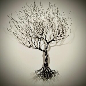 May include: A black wire sculpture of a tree with a twisted trunk and intricate branches. The tree is set against a white background.