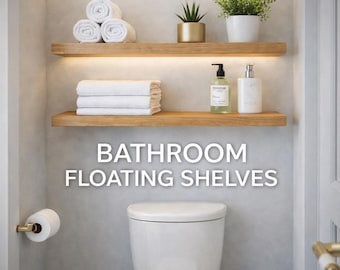 May include: Bathroom scene with two wooden floating shelves, holding rolled and folded white towels, plants, and soap dispensers. The text "BATHROOM FLOATING SHELVES" is displayed in white.