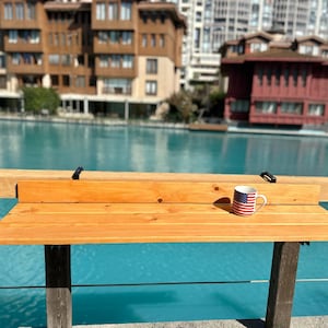 May include: A wooden table with a mug featuring the American flag. The table is made of light brown wood and has a simple design. The mug is white with red and blue stripes and stars.