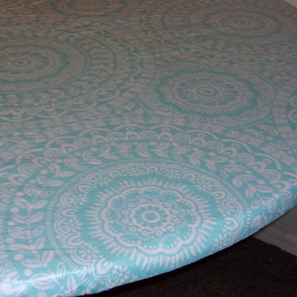 Fitted tablecloth. PEVA/ felt backing White with turquoise medallion 70" will fit 60" or 48x65 oval table. The 60x84  will fit a 48x72