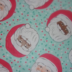 Fitted tablecloth. PEVA vinyl with felt backing 70 inch round to fit a 60 inch table . Ethnic Santas