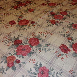 May include: Beige fabric with a plaid pattern and a floral design featuring red roses and green leaves.