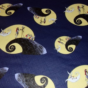 Peut inclure: Un tissu bleu avec un motif r&eacute;p&eacute;t&eacute; de Jack Skellington et Sally du film L'&Eacute;trange No&euml;l de monsieur Jack. Les personnages sont debout sur un croissant de lune jaune avec un tourbillon noir.